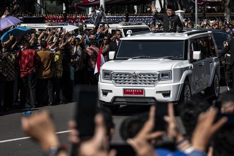 Presiden ke-7 RI Joko Widodo menyapa warga dari sunroof Pindad Maung Garuda saat melintas menuju Lanud Halim Perdanakusuma dari kompleks Istana Merdek